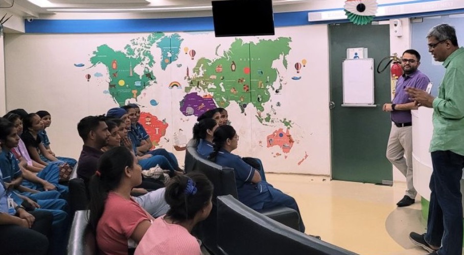 A training session for nursing staff in a hospital room, with a world map on the wall