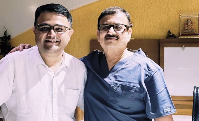 Two men with their arms around each other's shoulders, smiling at the camera